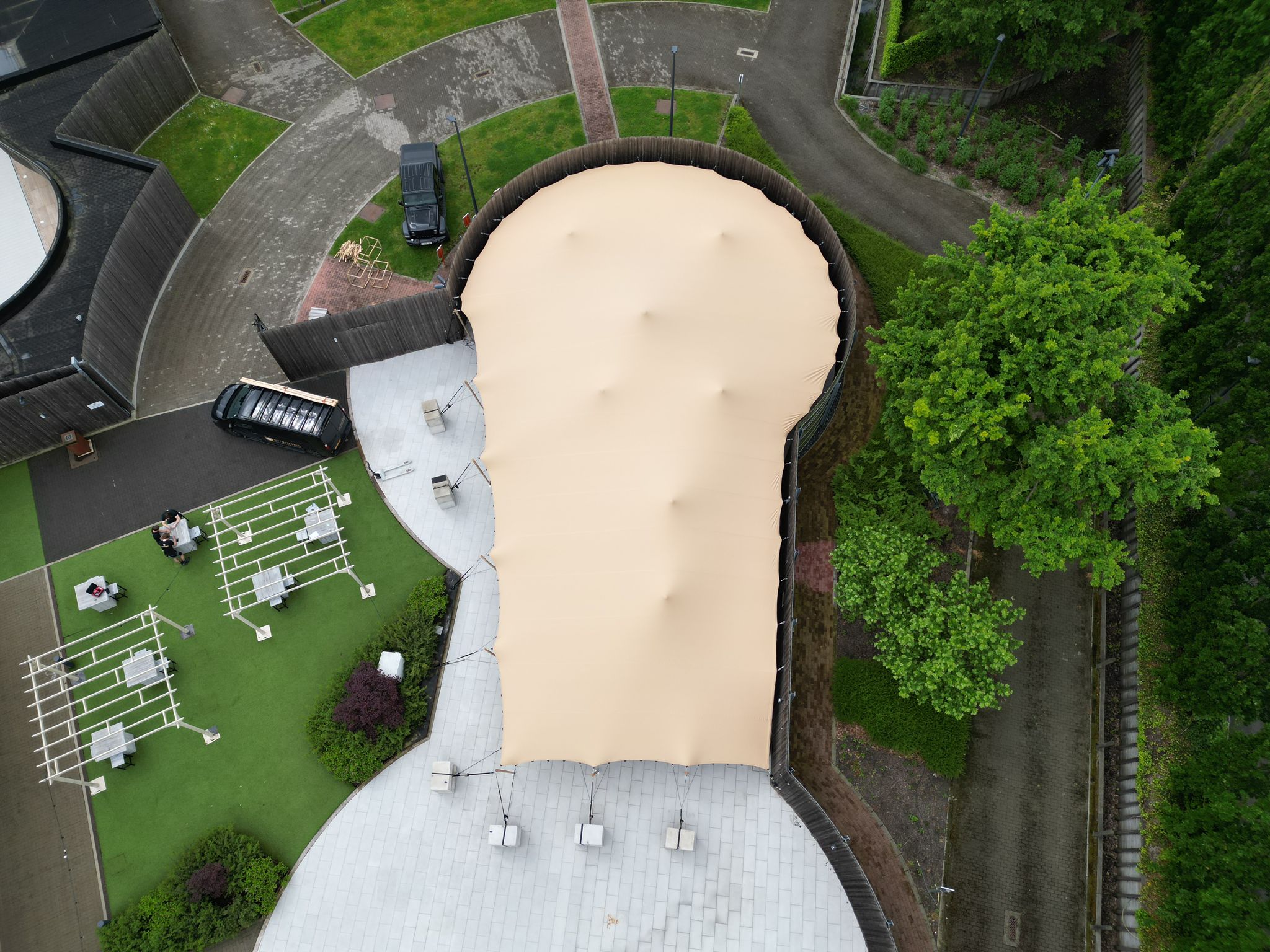 Special shape stretchtent bij Hotel Den Berg in Londerzeel gemaakt door Eurostretch in zandkleur van een grote oppervlakte om een buitenruimte te overdekken