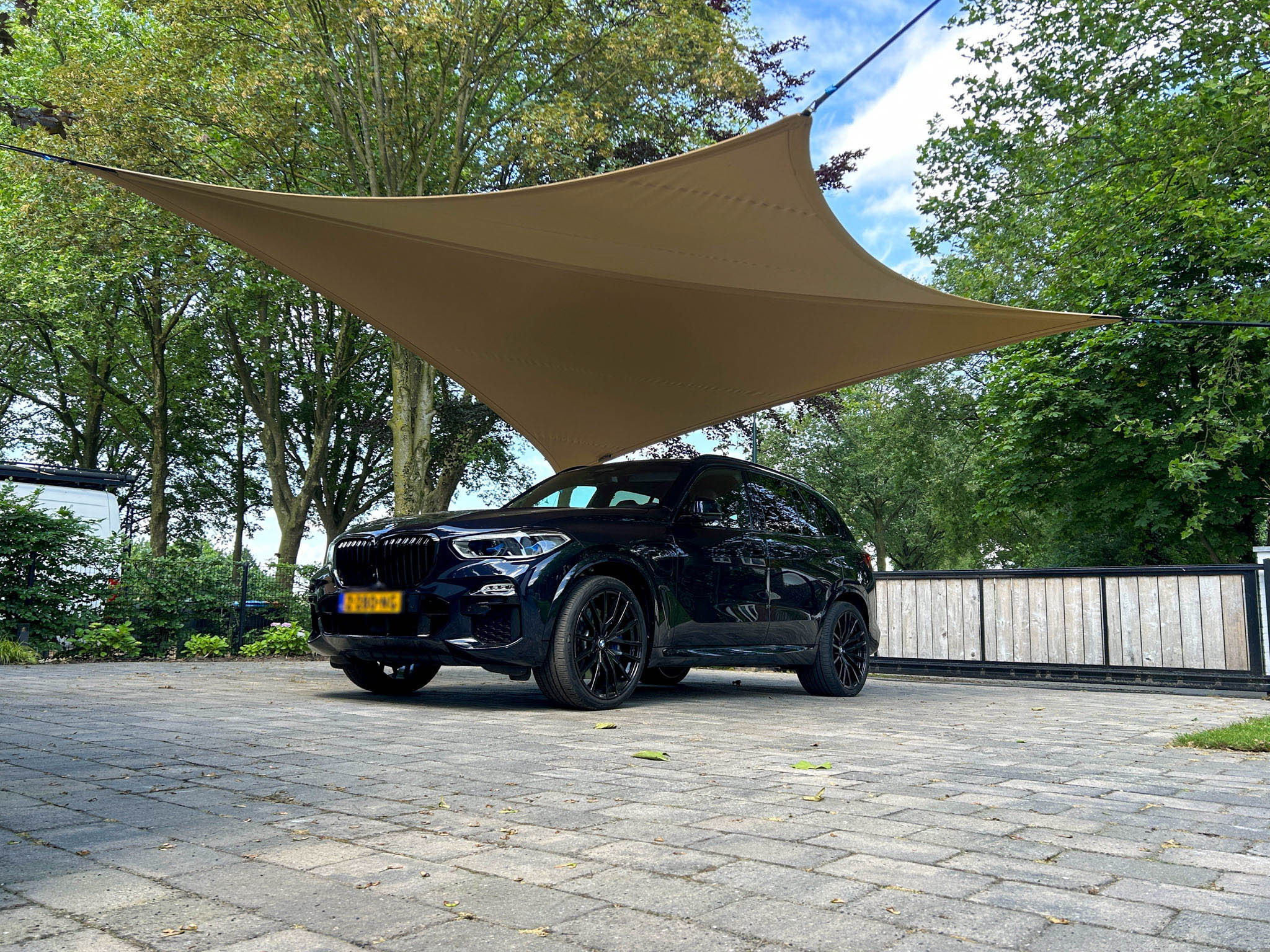 Zandkleurige tuinoverkapping gemaakt van stretchtentdoek. Ingezet als carpot