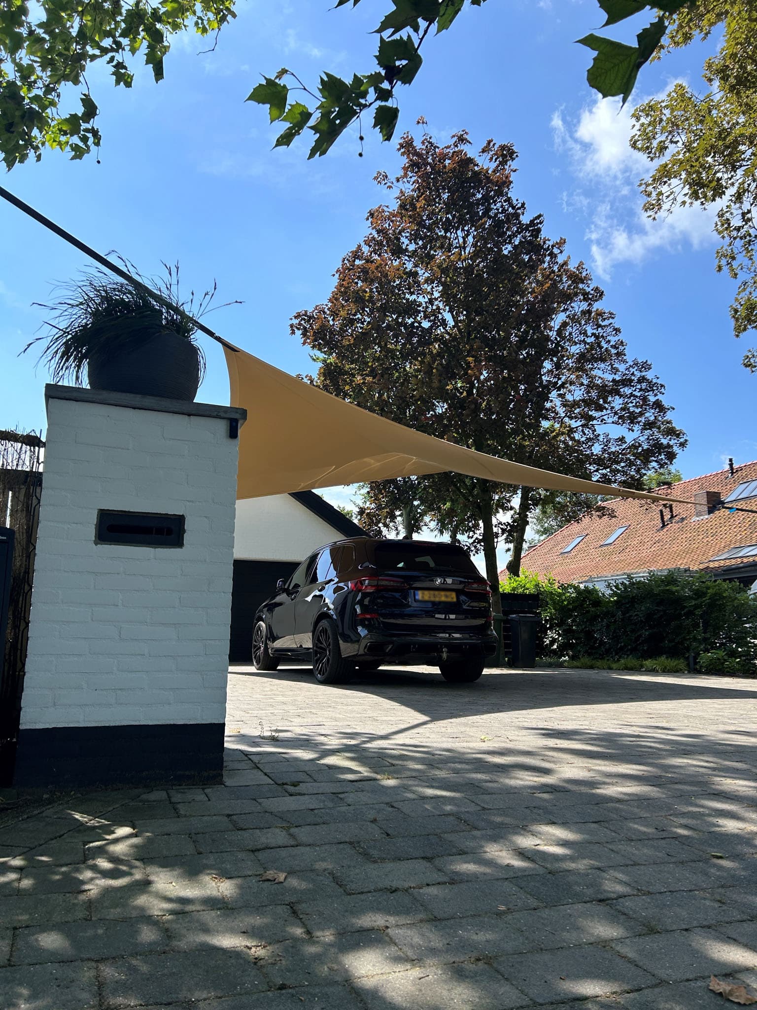 Middelgrote zandkleurige tuinoverkapping ingezet als carpot