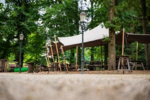 Zijkant van de stretchtent bij Stadsboerderij De Wesseler met houten palen